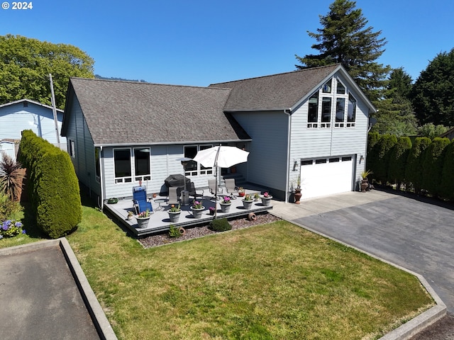 view of front of property with a garage, a wooden deck, and a front yard