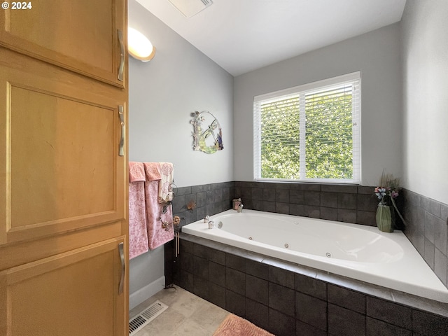 bathroom with tile patterned flooring and tiled tub