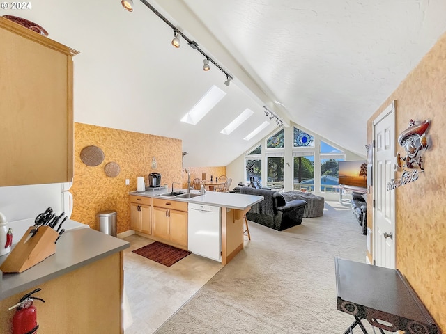 kitchen with sink, white dishwasher, track lighting, light brown cabinetry, and a breakfast bar