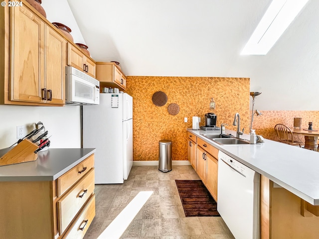 kitchen featuring white appliances, sink, light brown cabinets, a kitchen island, and hanging light fixtures