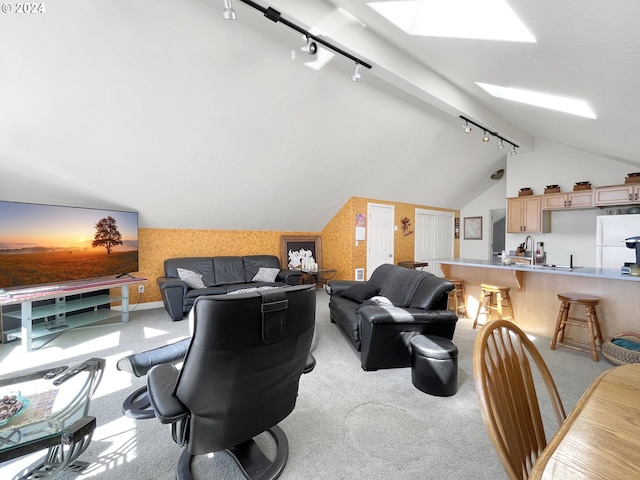 carpeted living room featuring rail lighting and vaulted ceiling with skylight