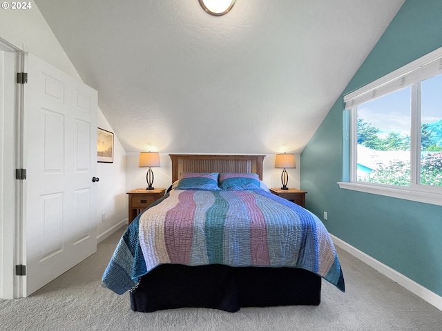 carpeted bedroom featuring a textured ceiling and lofted ceiling