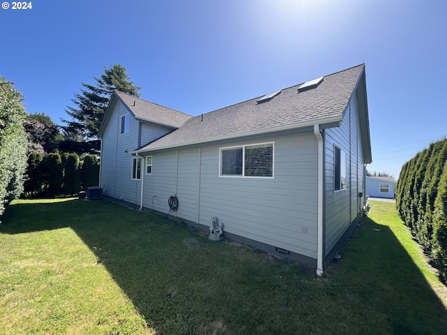 view of home's exterior with a lawn and central AC