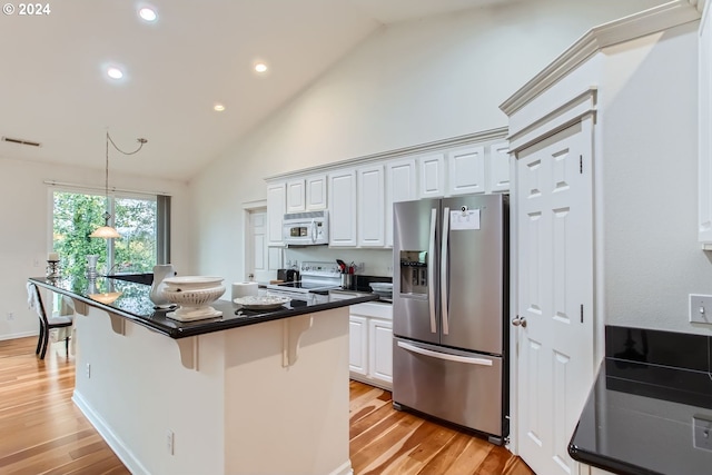 kitchen with a kitchen breakfast bar, white cabinetry, light hardwood / wood-style flooring, and white appliances