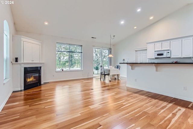 unfurnished living room featuring light hardwood / wood-style floors and high vaulted ceiling