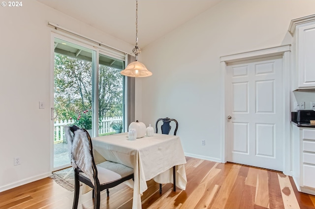 dining space with lofted ceiling and light wood-type flooring