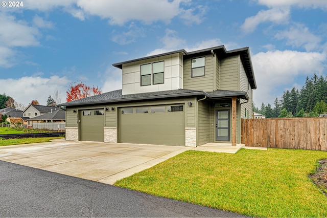 view of front of house with a garage and a front lawn