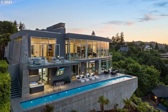 back house at dusk featuring outdoor lounge area and exterior bar