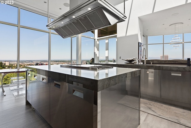 kitchen with island exhaust hood, floor to ceiling windows, and a wealth of natural light