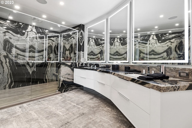 bathroom with an enclosed shower, double sink, and oversized vanity