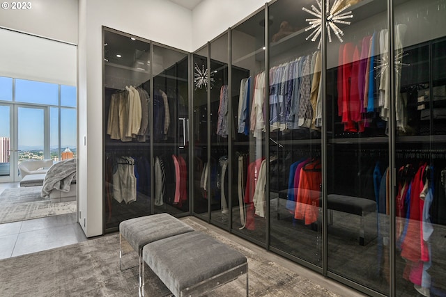 walk in closet featuring tile floors and an inviting chandelier