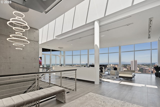 interior space with a high ceiling, an inviting chandelier, and a wall of windows