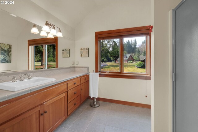 bathroom featuring vanity, vaulted ceiling, and a wealth of natural light