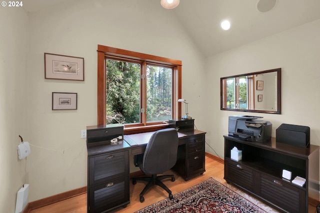 office space with light hardwood / wood-style floors and vaulted ceiling