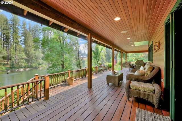 deck featuring an outdoor living space and a water view