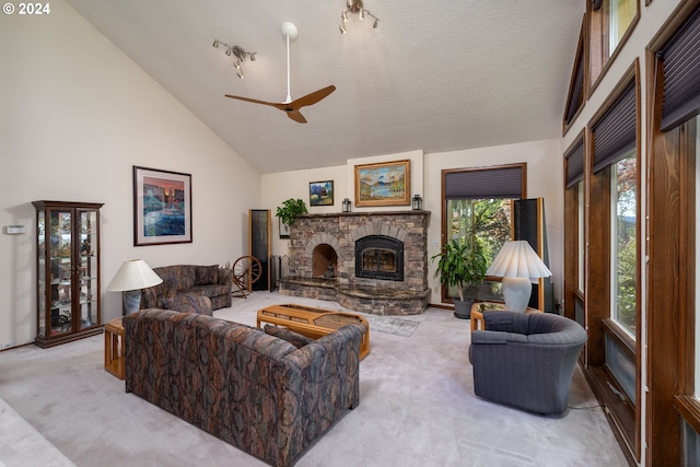 living room featuring a textured ceiling, a stone fireplace, light carpet, high vaulted ceiling, and ceiling fan