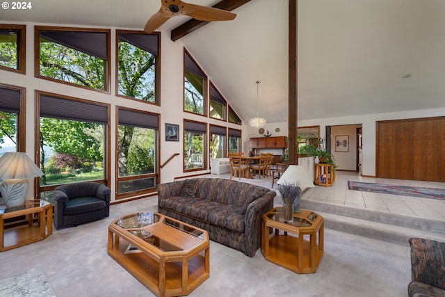 living room with ceiling fan with notable chandelier, high vaulted ceiling, light colored carpet, and beam ceiling