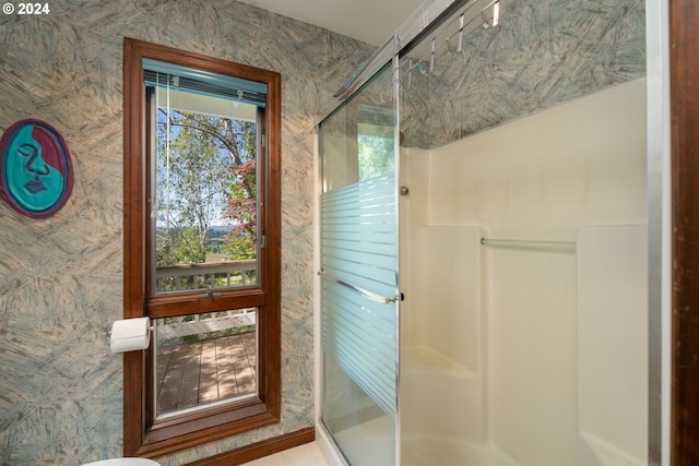 bathroom featuring a shower with door and plenty of natural light