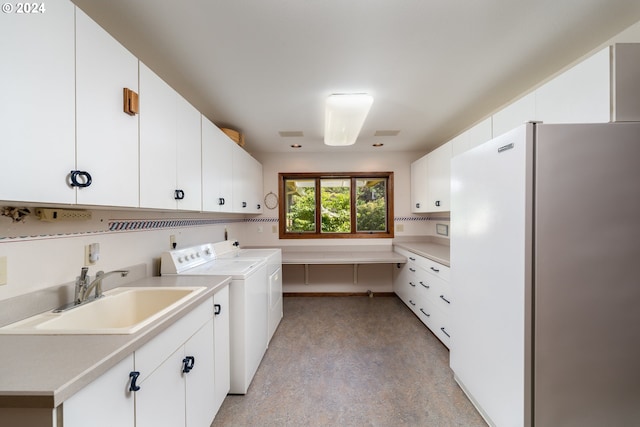 laundry area with independent washer and dryer, cabinets, and sink