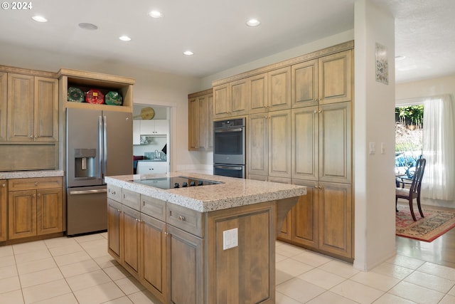 kitchen featuring light stone counters, appliances with stainless steel finishes, light tile floors, and a kitchen island