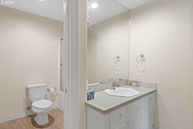 bathroom featuring wood-type flooring, oversized vanity, and toilet