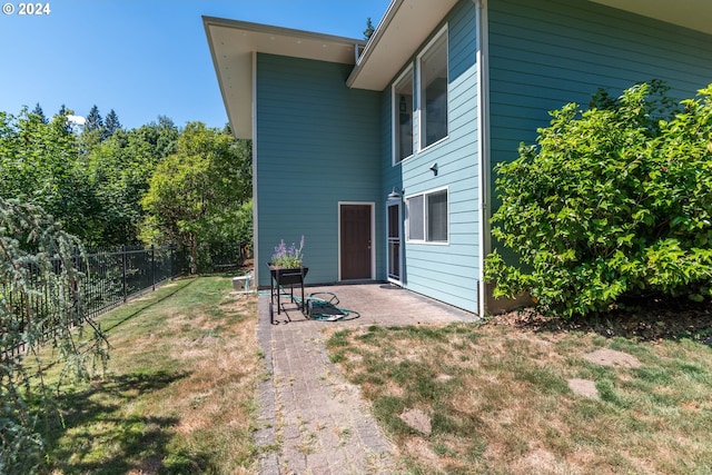 back of house with a patio area and a lawn