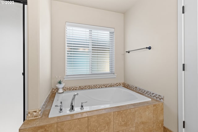 bathroom featuring tiled bath and plenty of natural light