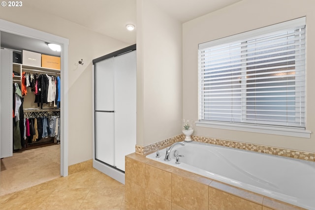 bathroom with tile patterned flooring and separate shower and tub