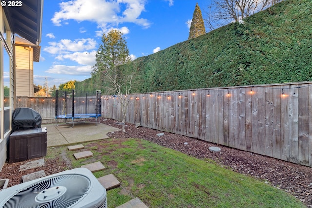 view of yard with a mountain view, a trampoline, a patio area, and central air condition unit