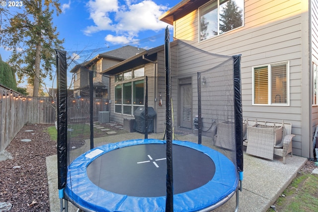 view of patio with a grill, central AC unit, and a trampoline