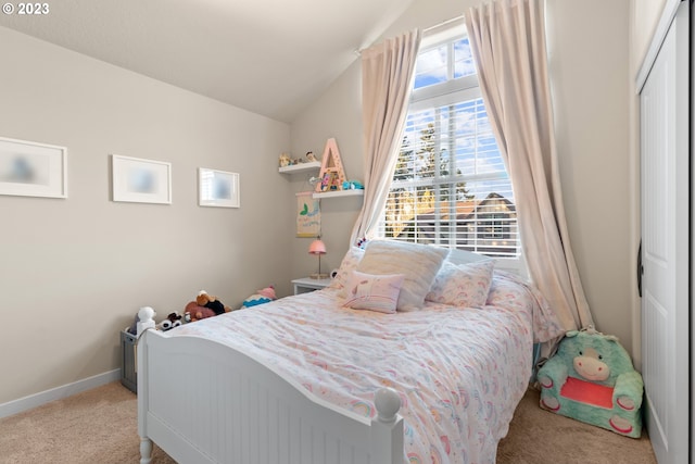 bedroom with light colored carpet, lofted ceiling, and a closet