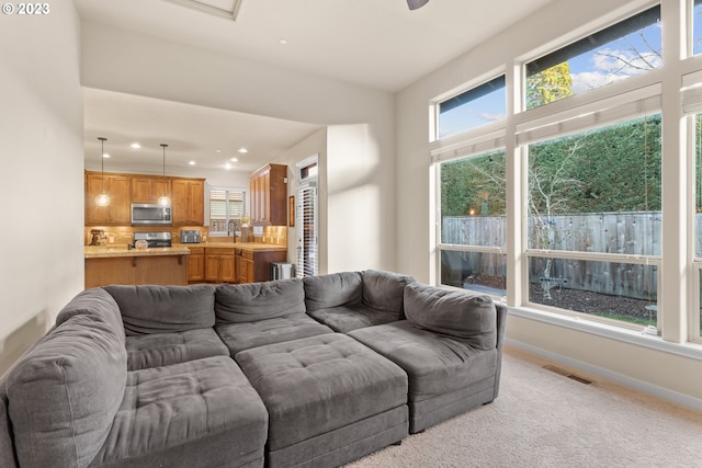 carpeted living room featuring sink