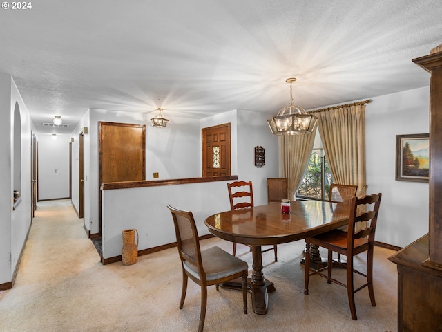 carpeted dining space with a textured ceiling and a notable chandelier