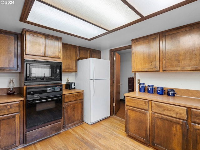 kitchen with black appliances and light hardwood / wood-style floors