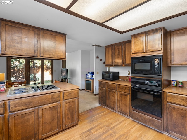 kitchen with light wood-type flooring and black appliances