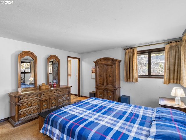 bedroom featuring light colored carpet and a textured ceiling