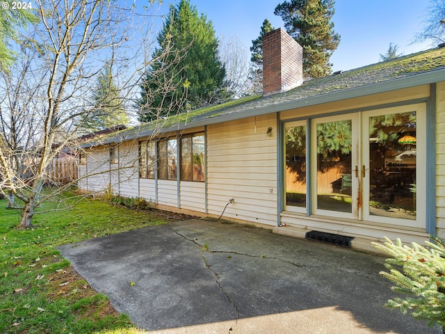 rear view of property featuring a patio area and a lawn