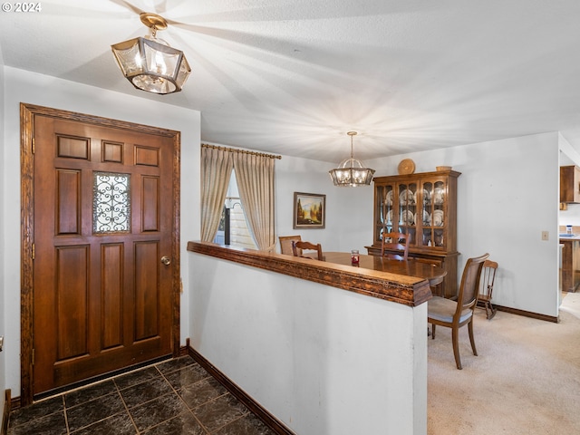 carpeted entrance foyer featuring a chandelier