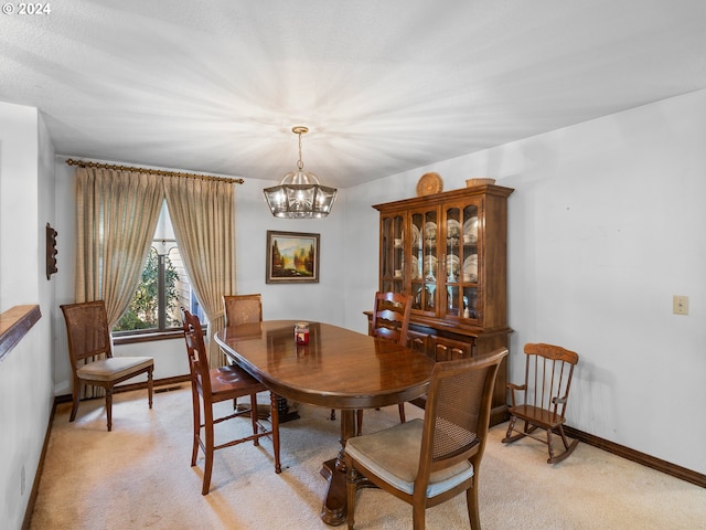 dining area featuring light carpet and a notable chandelier