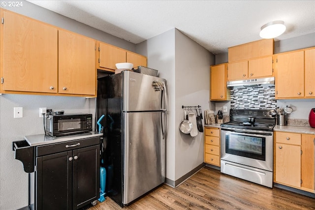 kitchen with light brown cabinetry, hardwood / wood-style flooring, appliances with stainless steel finishes, and tasteful backsplash