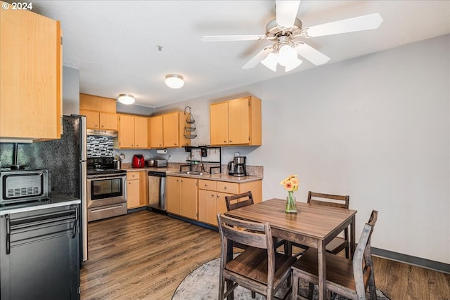 kitchen featuring decorative backsplash, dark wood-type flooring, light brown cabinets, stainless steel appliances, and ceiling fan