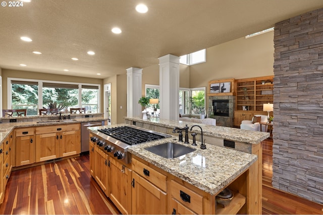 kitchen with dark hardwood / wood-style flooring, a center island with sink, stainless steel appliances, and sink