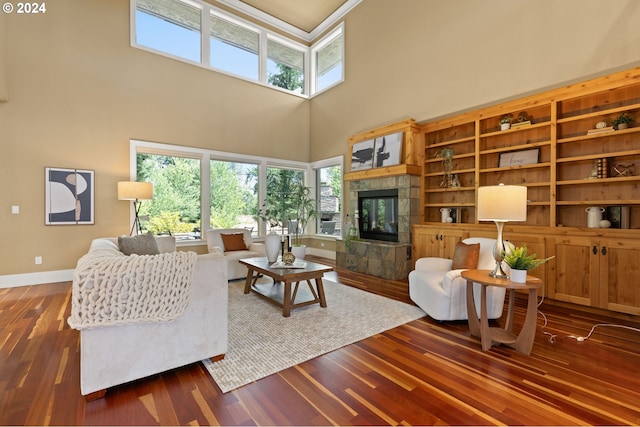 living room with a stone fireplace, dark hardwood / wood-style flooring, and a high ceiling