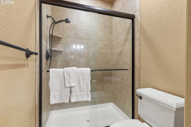 bathroom with toilet and an enclosed shower