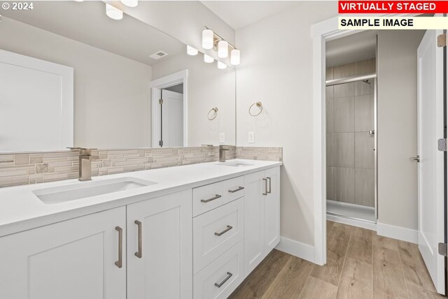 bathroom featuring vanity, walk in shower, decorative backsplash, and hardwood / wood-style floors