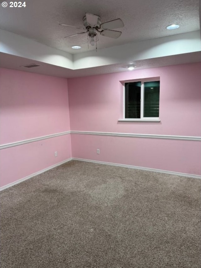 empty room featuring ceiling fan, carpet, and a textured ceiling