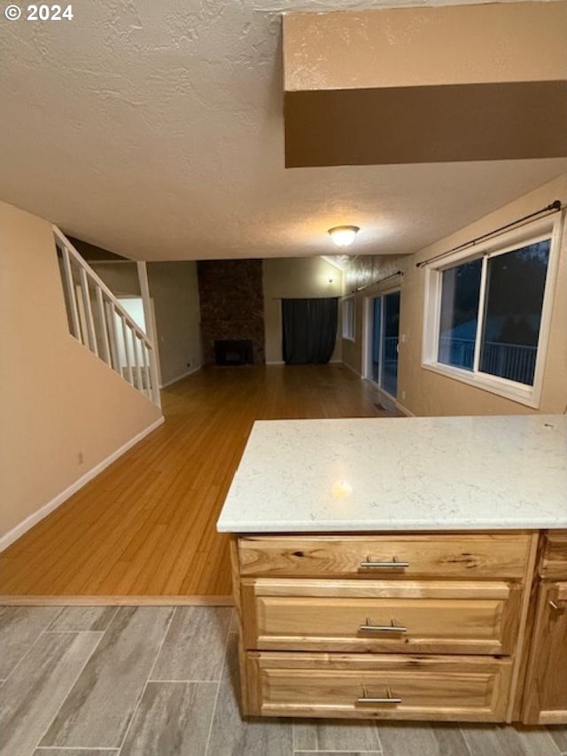 kitchen with a textured ceiling and light hardwood / wood-style flooring