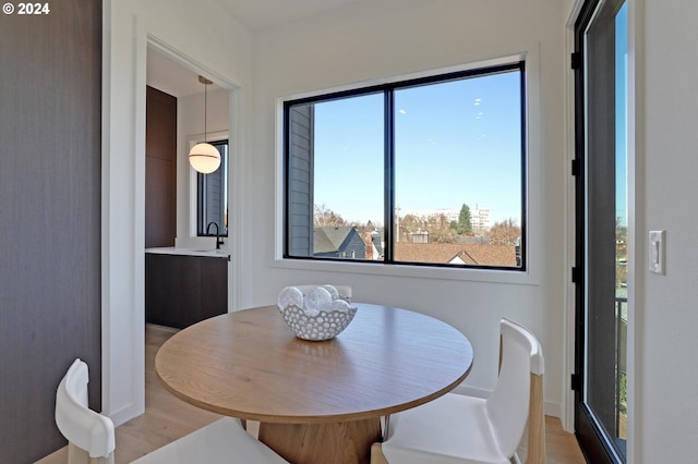 dining space featuring light wood-type flooring and sink