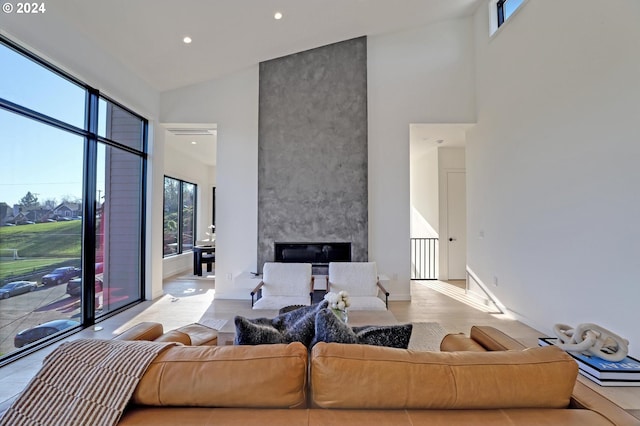 living room featuring a large fireplace, light hardwood / wood-style floors, and high vaulted ceiling