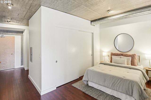 bedroom featuring dark wood-type flooring and a closet